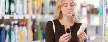 mulher a ler o rótulo de um desodorizante