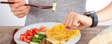 homem a olhar para o relógio enquanto come
