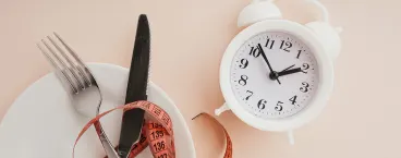 relógio, fita-métrica e prato dispostos numa mesa