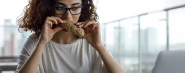 mulher em frente ao computador a comer pão 