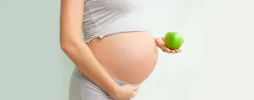 grávida com uma maçã na mãográvida com uma maçã na mão