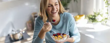 mulher a comer iogurte com fruta