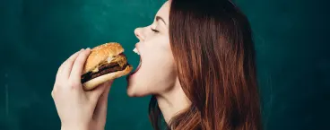 rapariga a comer um hambúrguer