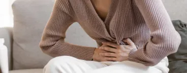mulher com desconforto abdominal devido à flatulência