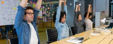 4 pessoas em aula de ginásio a fazer alongamentos