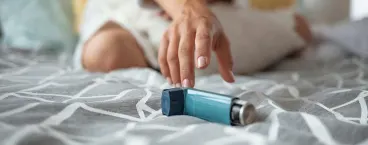 mulher junto a inalador para tratar asma