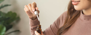 mulher a segurar frasco de óleo de cbd