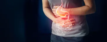 mulher sentada com dores abdominais a conversar com o médico