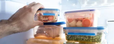 homem a pôr comida quente no frigorífico