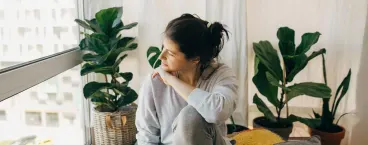 mulher triste a olhar pela janela