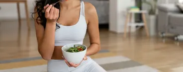 rapariga sentada a comer uma salada