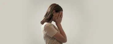 Mulher preocupada com as mãos no rosto