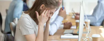 senhora com sinais de stress durante o trabalho