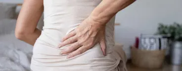 mulher com mão na lombar 