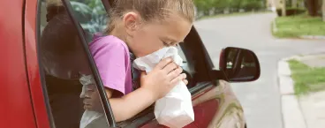 menina a sentir-se enjoada numa viagem de carro