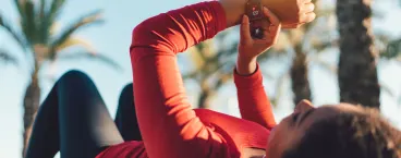 mulher pós-treino deitada a medir o ritmo cardiaco