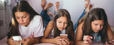 3 adolescentes ao telemóvel