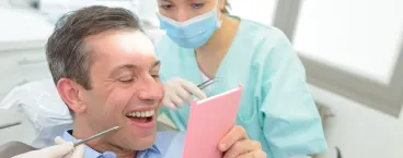 paciente vê-se ao espelho após colocação de implante dentário