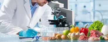 investigador a observar alimentos no microscópio 