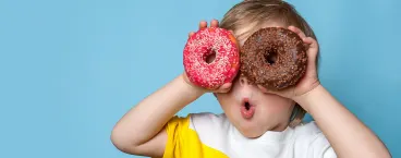 menino com dois donuts nas mãos
