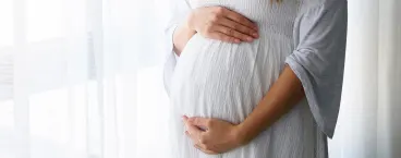 mulher a acariciar a barriga em casa
