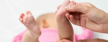 mãe a segurar pezinho do bebé
