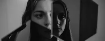 mulher com a imagem fragmentada ao espelho