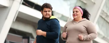 dois jovens com excesso de peso a fazer exercício físico