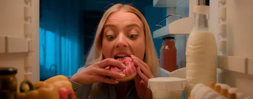 rapariga a comer um dónute à noite