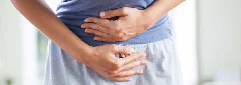 mulher com mãos sobre a barriga