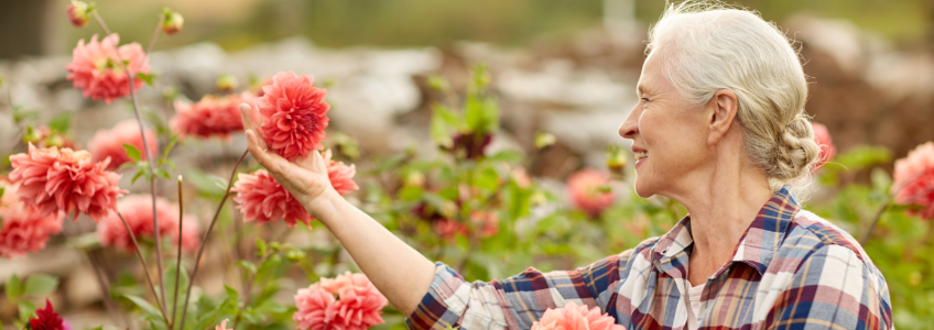 Idosa a passear enquanto cuida de flores