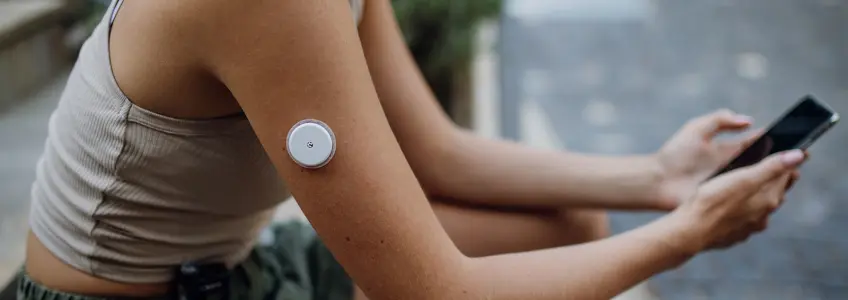 mulher com sensor no braço para monitorizar a glicose no sangue