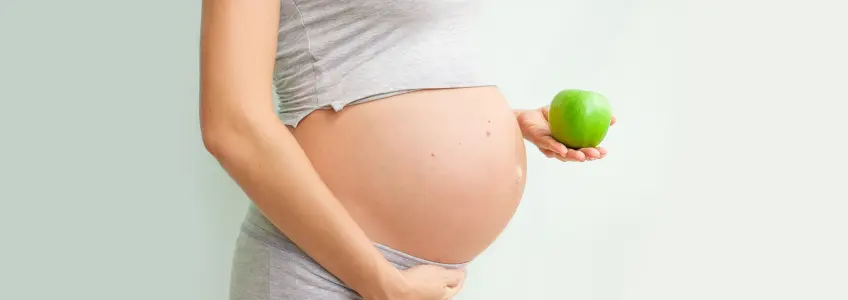 grávida com uma maçã na mãográvida com uma maçã na mão
