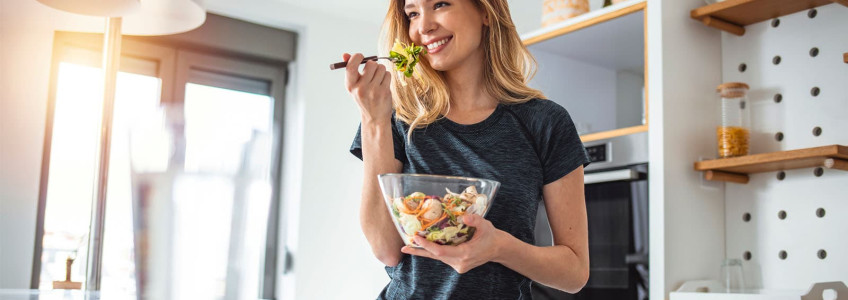 mulher a comer salada da taça