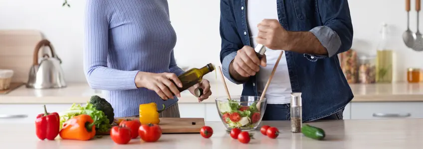 mulher a temperar salada com azeite