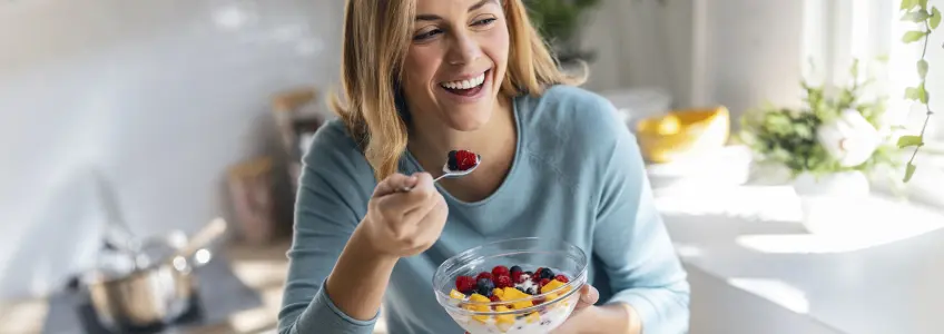 mulher a comer iogurte com fruta