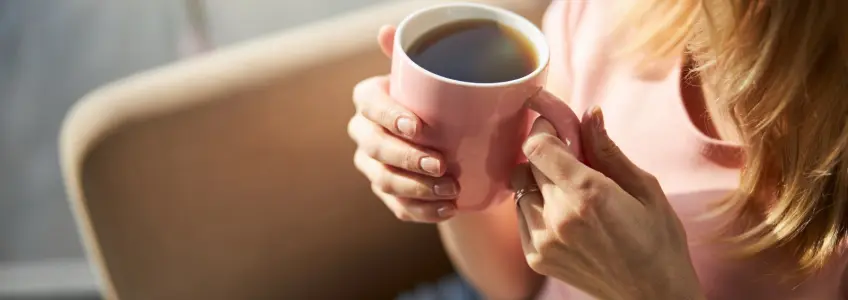 senhora a segurar em chávena de café