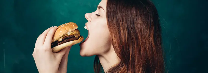rapariga a comer um hambúrguer