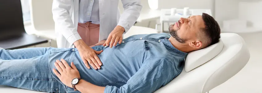 médica a tocar na barriga de paciente deitado na marquesa