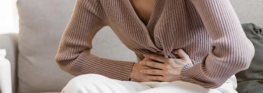 mulher com desconforto abdominal devido à flatulência