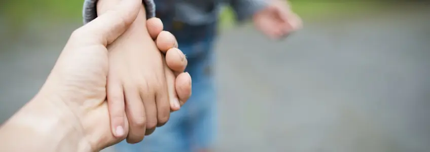 mão de mãe e criança entrelaçadas