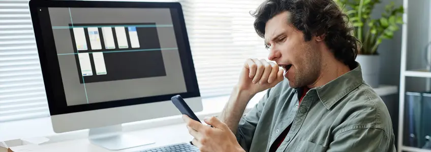 rapaz boceja enquanto olha para o telemóvel
