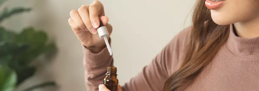 mulher a segurar frasco de óleo de cbd
