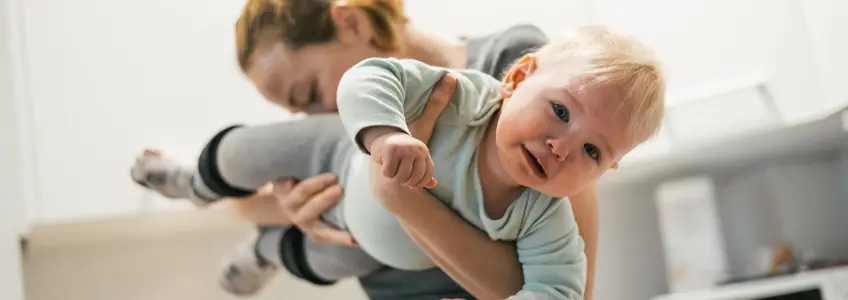 mãe a cheirar na zona da fralda do bebé
