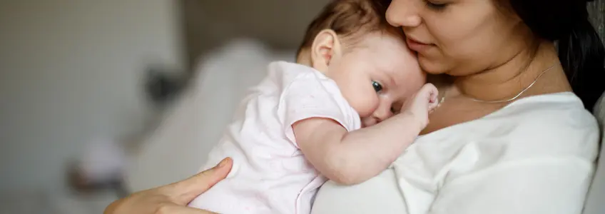pai a segurar bebé de barriga para baixo