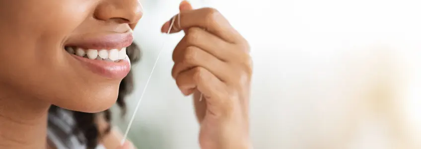 mulher com fio dentário na mão