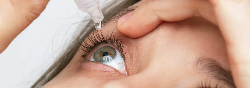 rapariga a colocar gotas nos olhos