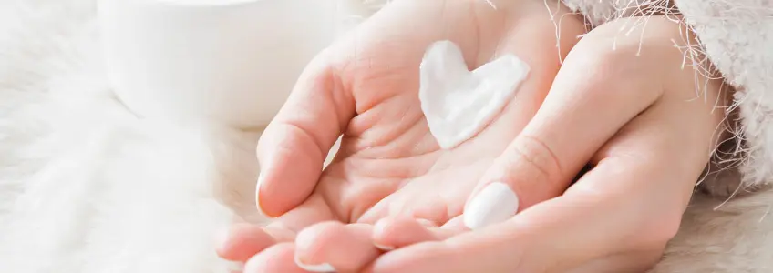 mulher com porção de creme na mão em forma de coração