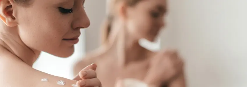 mulher a colocar creme nas mãos