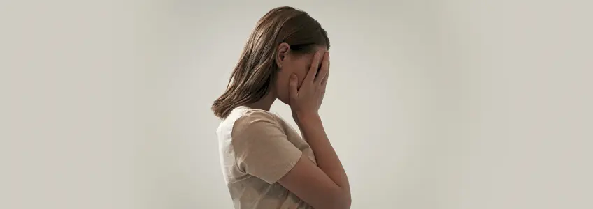 Mulher preocupada com as mãos no rosto